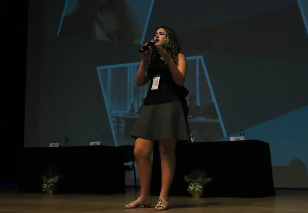 Laura Lorrana palestreando sobre olimpíadas científicas para outros estudantes - News - notícia olimpíadas científicas